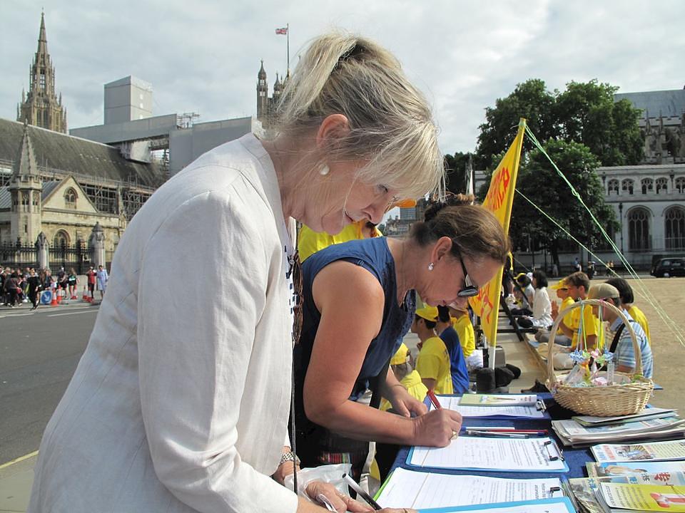 Dve žene potpisuju peticiju za prekid progona Falun Gonga u Kini