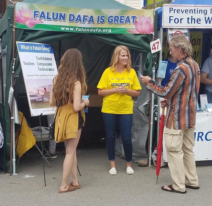 Praktikant govori prolaznicima o Falun Dafa na 59. sajma umjetnosti Ann Arbor.