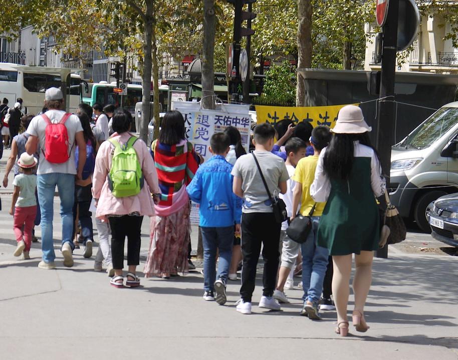 Kineski turisti čitaju Falun Gong materijale blizu Ajfelovog tornja