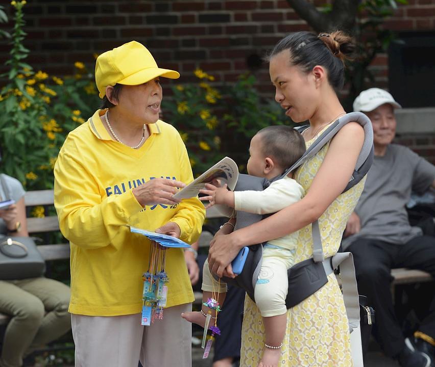 Lokalna stanovnica ćaska sa praktikantom Falun Gonga.