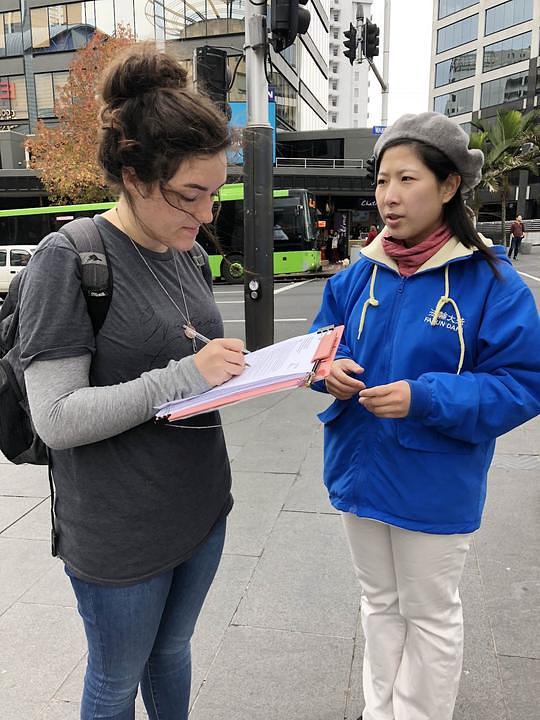 Bridget Connolly potpisuje peticiju protiv progona Falun Gonga u Kini. Teško joj je bilo vjerovati da bi ljudi mogli biti ubijeni samo zbog svoje miroljubive prakse. Rekla je da će o tome pričati prijateljima putem društvenih medija.
