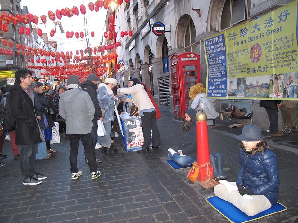 Praktikanti demonstriraju izvođenje vježbi i dijele Falun Gong materijale.