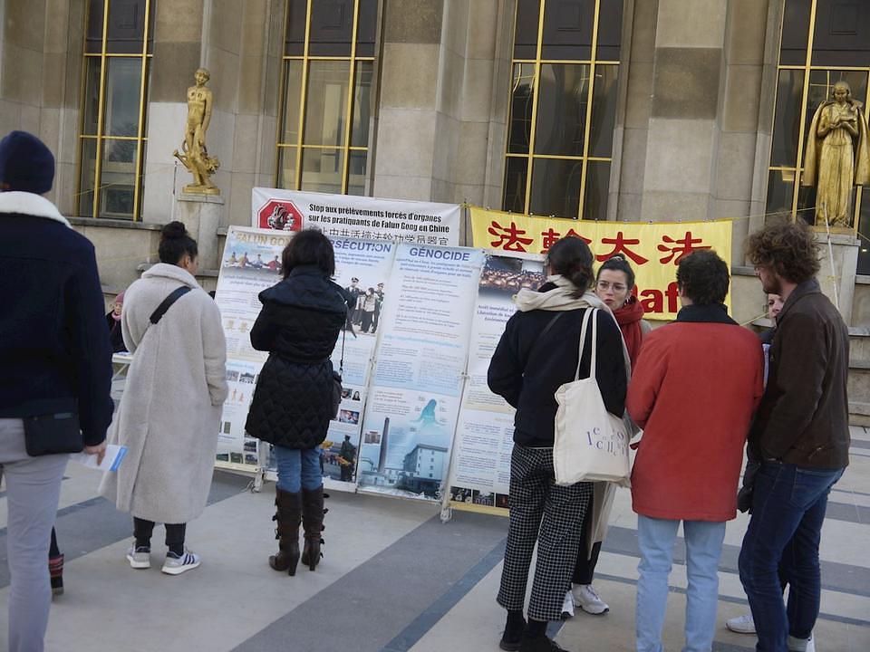 Turisti se zaustavljaju da bi čitali izložene plakate i razgovarali sa praktikantima o progonu Falun Gonga u Kini.