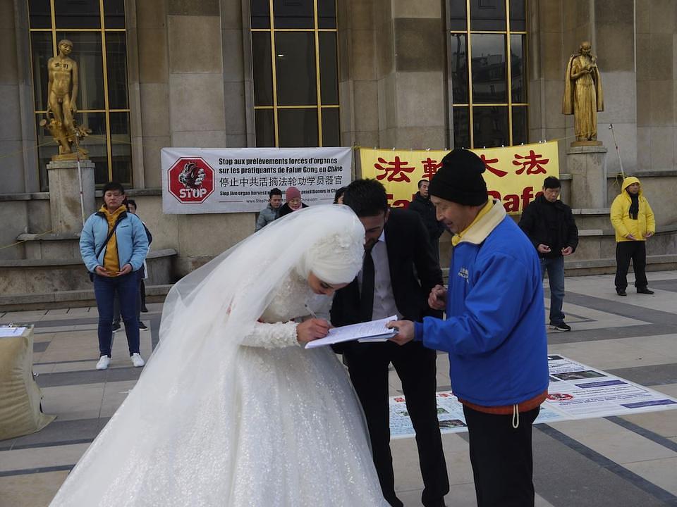 Jedan par mladenaca potpisuje peticiju protiv prisilne žetve organa u Kini.