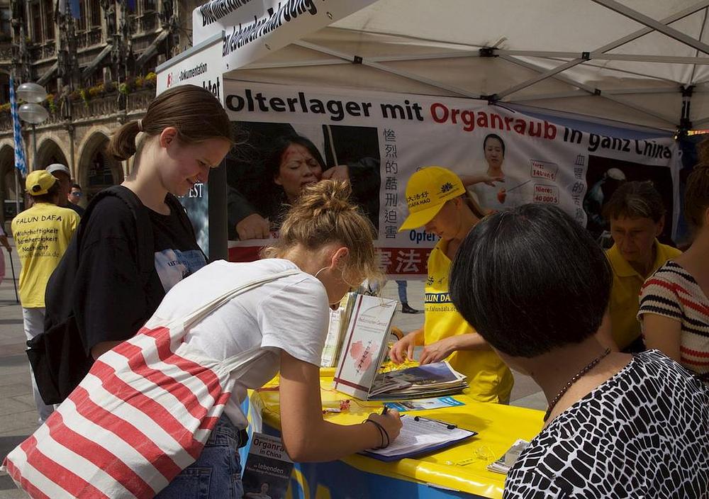 Prolaznici na Marienplatzu potpisuju peticiju kojom osuđuju progon.