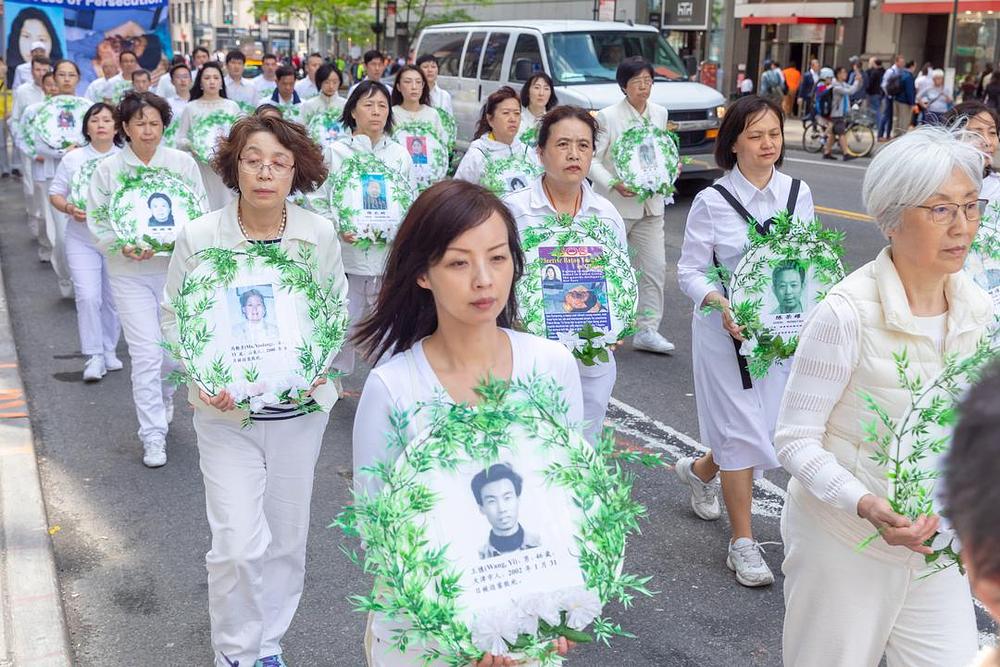 Praktikanti nose slike Falun Dafa praktikanata koji su izgubili živote zbog progona u Kini