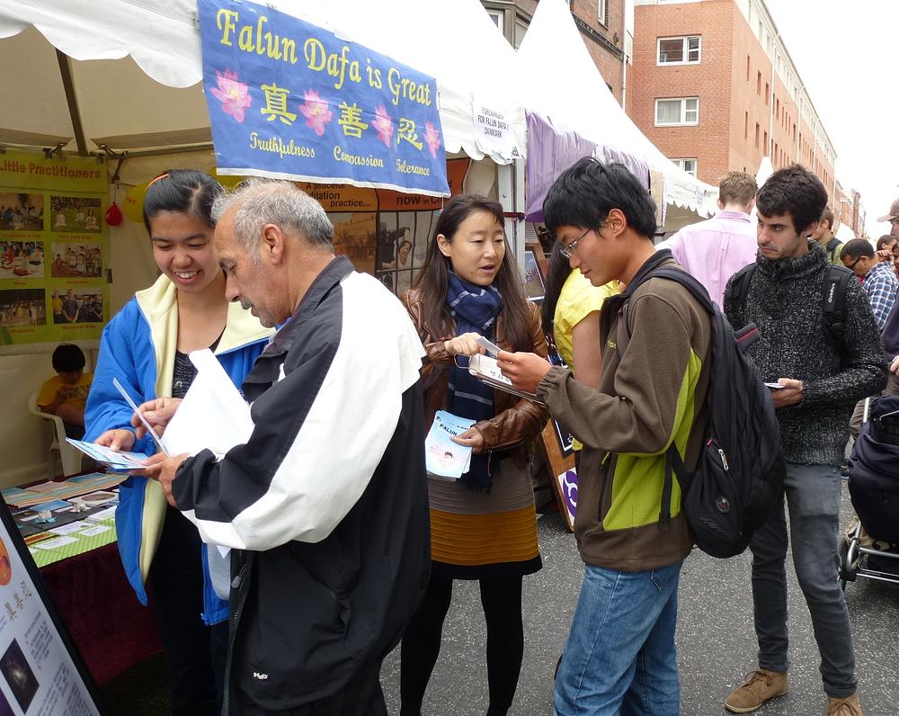 Praktikanti razgovaraju s ljudima o Falun Gongu.