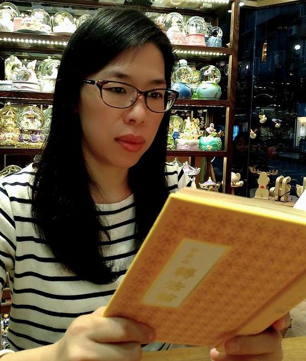 Chen Yiqing, vlasnica prodavaonice muzičkih kutija u Tajpeju, čita *Zhuan Falun*, glavna učenja Falun Dafe.