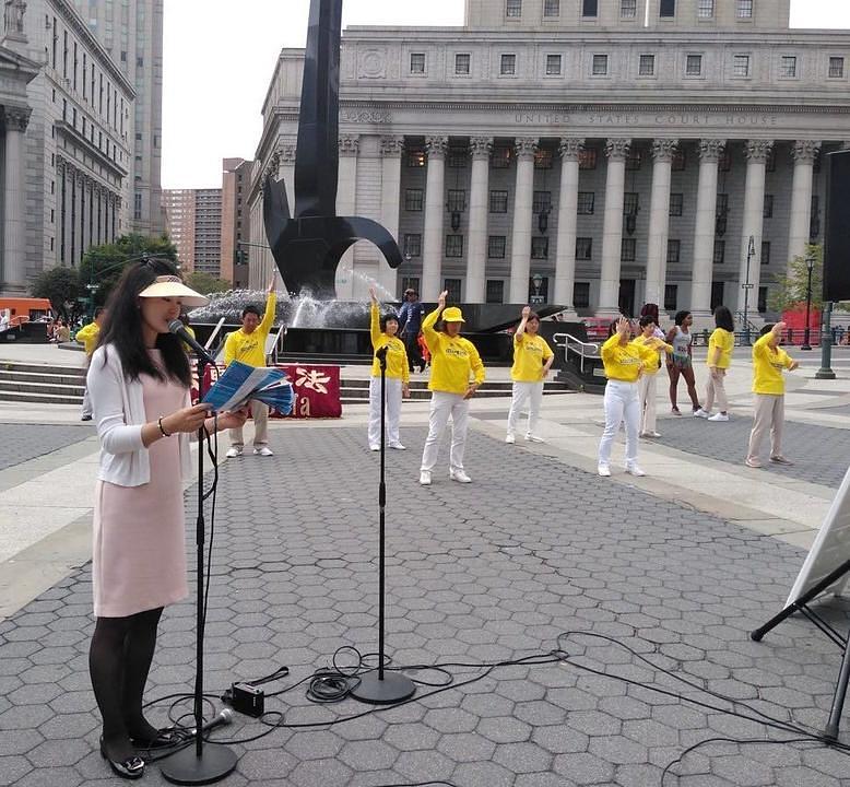 Praktikantica daje osnovne informacije o Falun Dafa, dok grupa izvodi pokrete