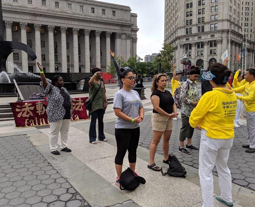 Prolaznici uče Falun Gong vježbe 