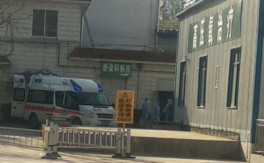 Medicinsko osoblje stoji ispred Narodne bolnice grada Dezhou i čeka da primi pacijente