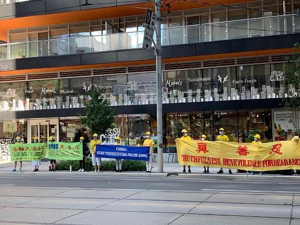 Učenici iz ljetnog Minghui kampa drže istaknute transparente na manifestaciji u centru Toronta kako bi podigli svijest o progonu u Kini 