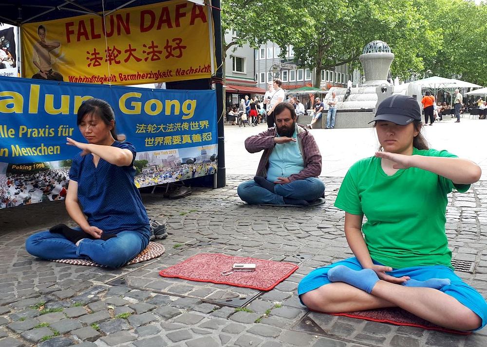 Praktikanti demonstriraju Falun Dafa vježbe u centru grada Dortmunda.