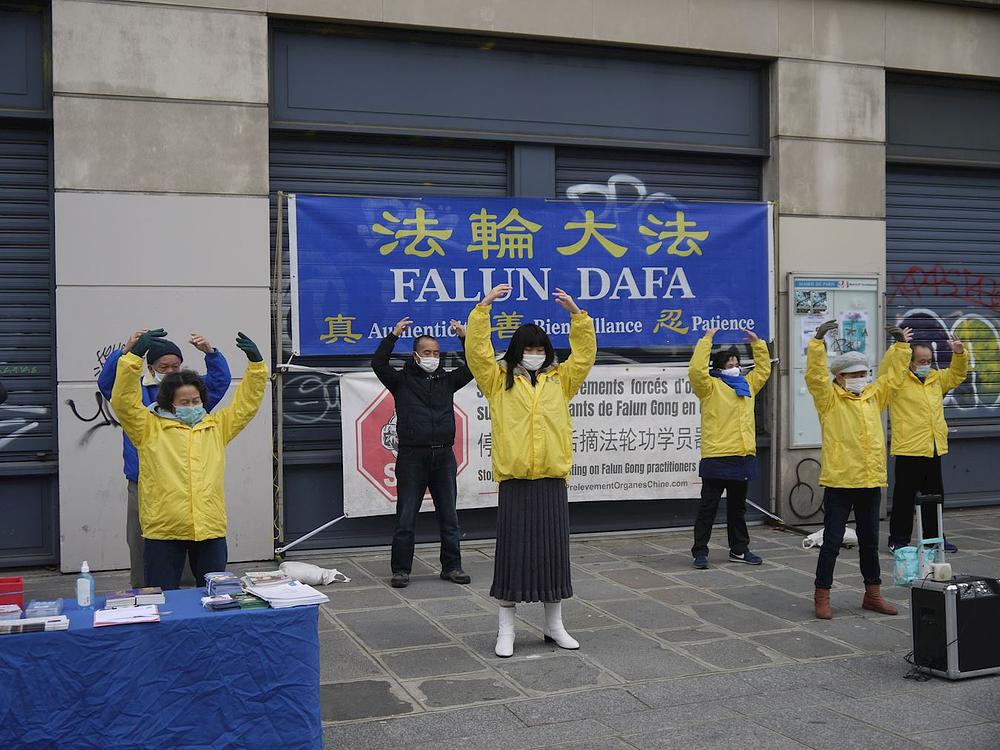 Praktikanti demonstriraju izvođenje Falun Dafa vježbi 26. decembra 2020. u Parizu.
