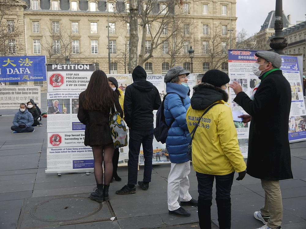 Prolaznici koji se zaustavljaju da bi saznali više o Falun Dafa i progonu.