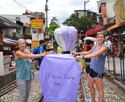 Jeanne (lijevo) se na Tajvanu priprema da pusti u zrak leteći lampion s natpisom "Falun Dafa je dobar".