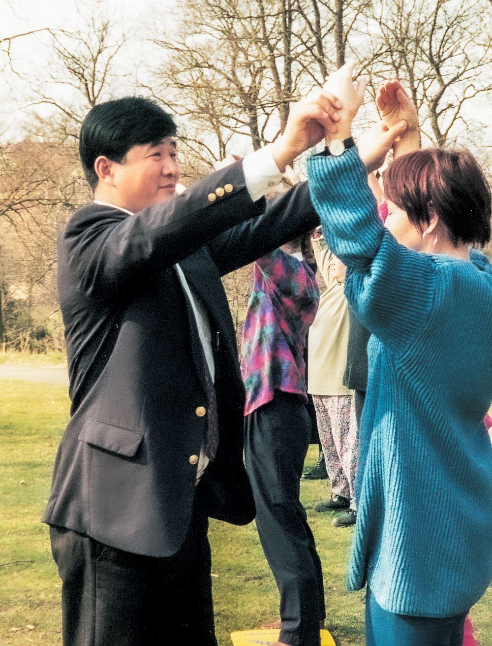 Učitelj Li vodi i ispravlja pokrete ruku učenice tokom podučavanja Falun Dafa u Göteborgu, u aprilu mjesecu 1995. godine 