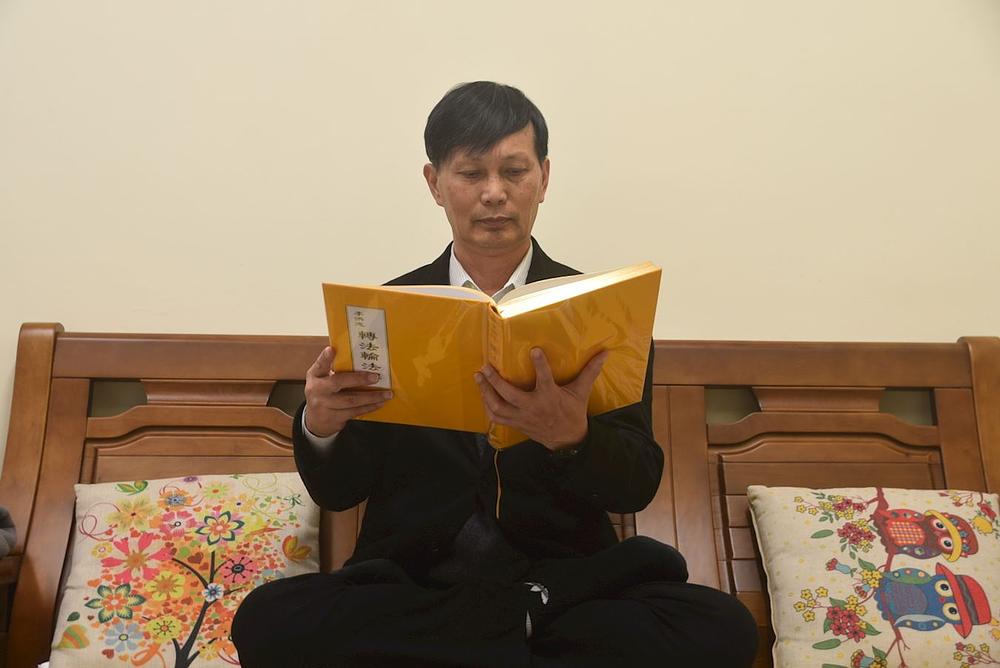 Gosp. Liao čita Falun Dafa knjigu za koju kaže da je najveće blago u njegovom životu.