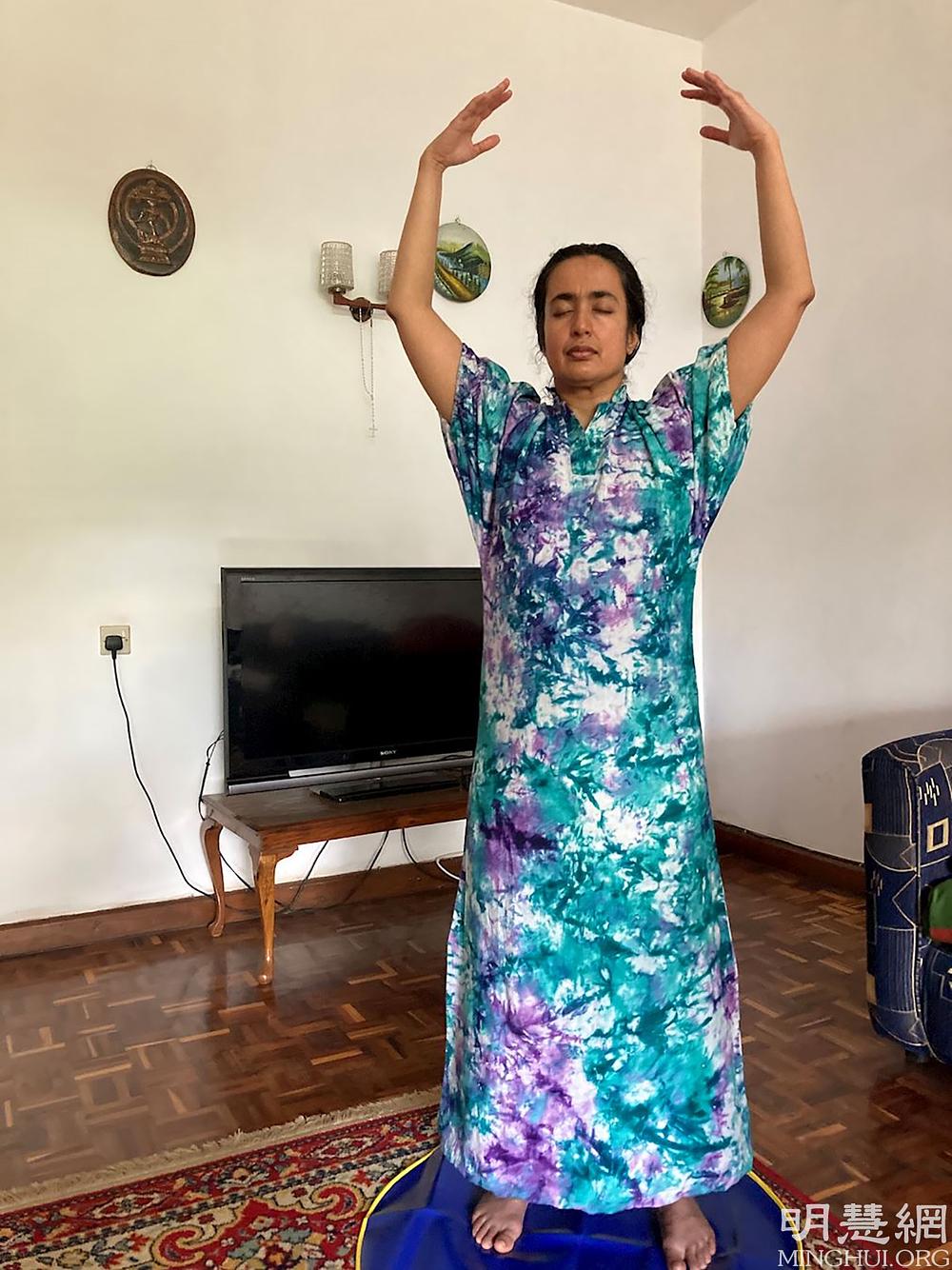 Kamranova majka radi drugu Falun Dafa vježbu.