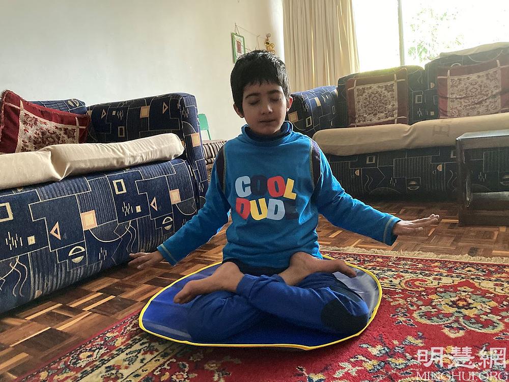 Desetogodišnji Kamran radi petu Falun Dafa vježbu, meditaciju.