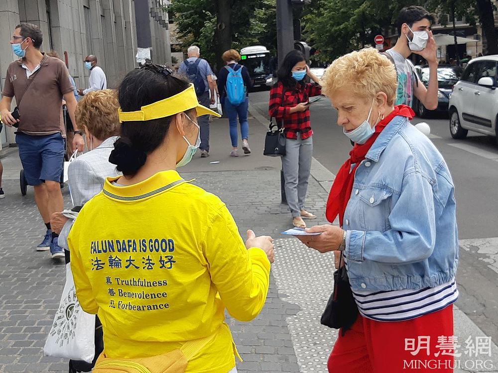 Parižani slušaju dok Falun Dafa praktikanti opisuju progon u Kini.
