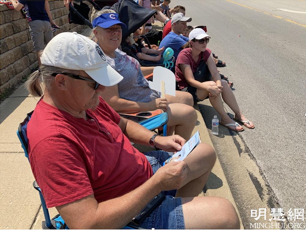 Gospodin i gospođa Soeldner su se zadubili u čitanje letaka o Falun Gongu dok su čekali da parada počne.