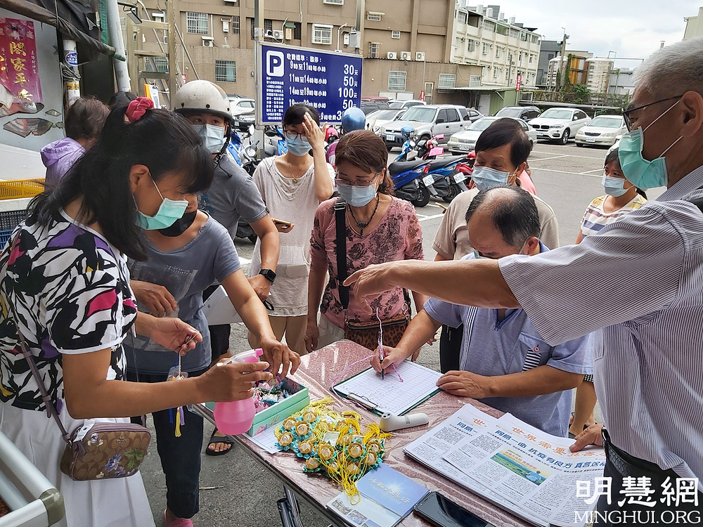  Uz podsjećanje kupaca na sanitarne procedure, praktikanti na večernjoj pijaci Douliu davali informacije o Falun Dafa i dijelili lotosove cvjetove.