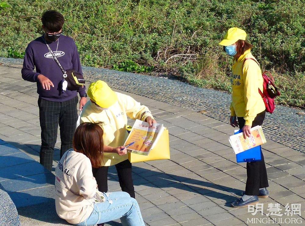 Praktikant predstavlja Falun Dafa posjetiocu parka: Od njegovog predstavljanja 1992. godine, Falun Dafa se sada prakticira u više od 100 zemalja.