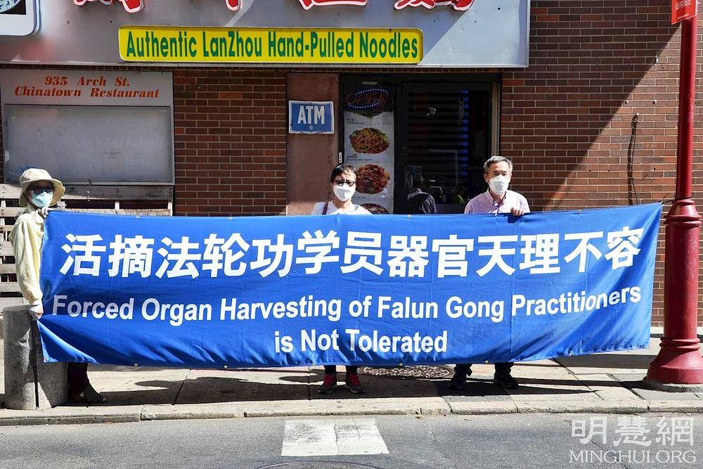 Praktikanti na skupu drže transparent kako bi okončali prisilnu žetvu organa u Kini.