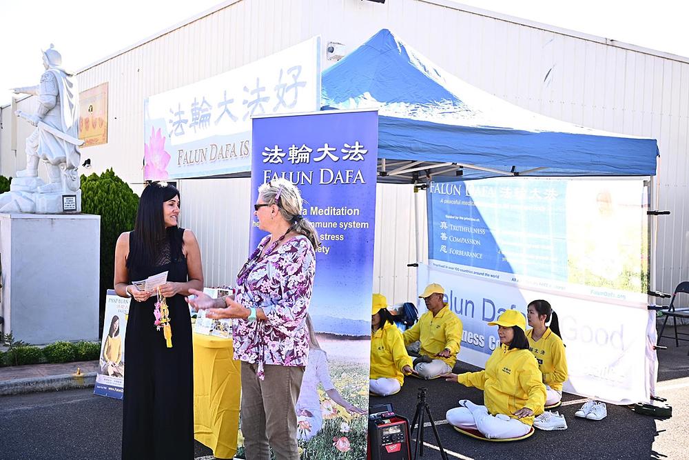 Pored demonstracije vježbi na izložbi bonsaija i orhideja, praktikantica razgovara o Falun Dafi s lokalnom stanovnicom (prva slijeva).