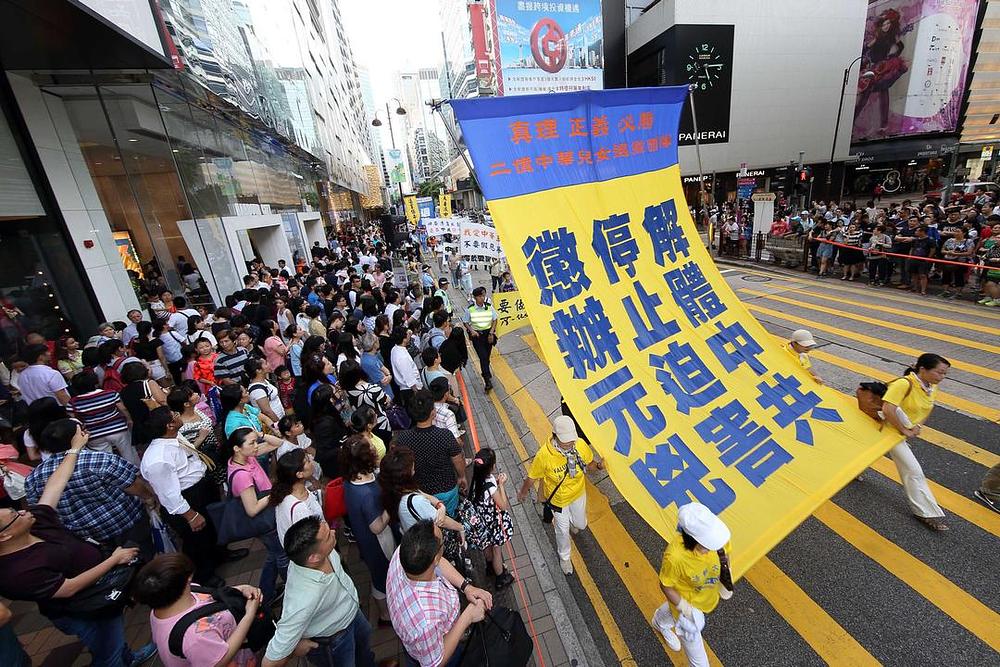 Na transparentu piše: „Dezintegrirati Komunističku partiju i zaustaviti progon“