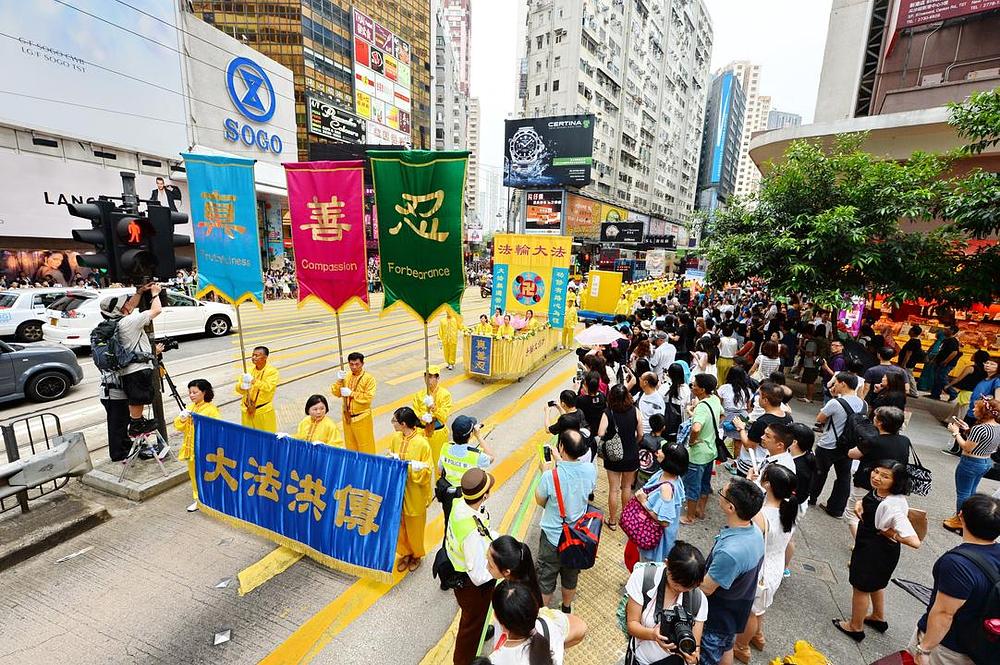 Na transparentima stoji:“ Falun Dafa“ i „Istinitost-Dobrodušnost-Tolerancija“