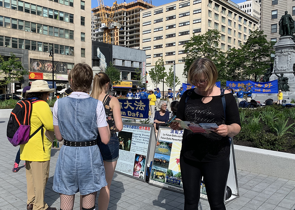 Ljudi zastaju da bi čitali informacije o Falun Dafa i kako ga KPK progoni. 