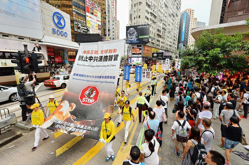 Na plakatu piše: „Zaustavite žetvu organa od praktikanata Falun Gonga iza koje stoji Kineska država“