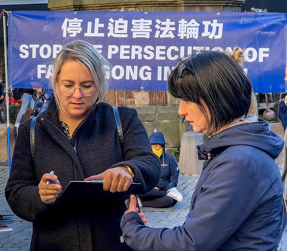   Ljudi potpisuju peticiju za potporu prekida progona u Kini.