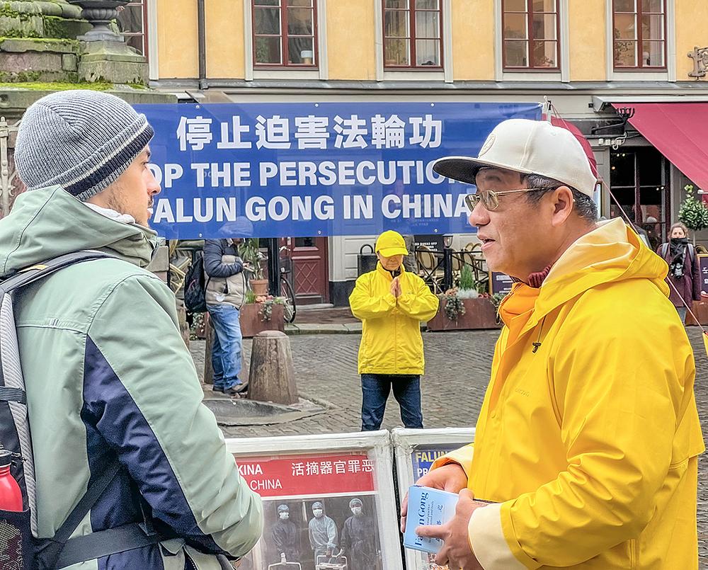  John (lijevo) iz Italije rekao je da je naučio mnogo o Falun Dafa razgovarajući s praktikantima. On misli da je Falun Dafa izvanredan i rekao je da će sigurno saznati više o njemu.