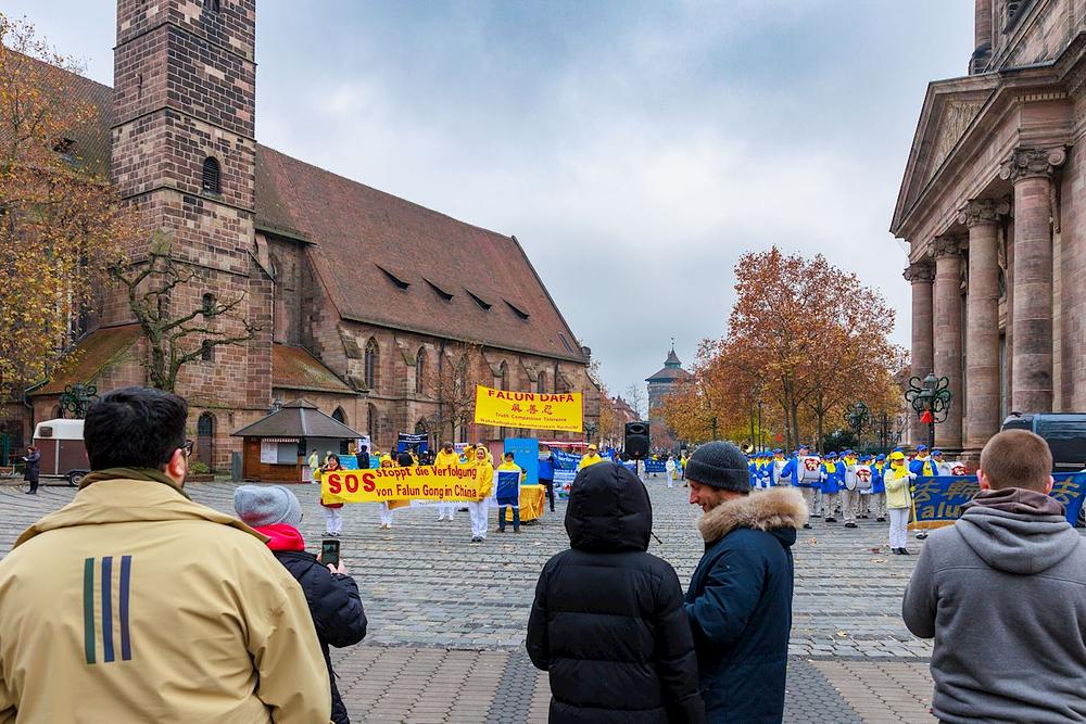  
Falun Dafa praktikanti na Jakobsplatzu razgovaraju sa prolaznicima o progonu u Kini