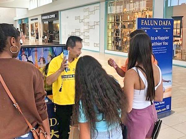 Praktikanti predstavljaju Falun Dafa kupcima u trgovačkom centru. 