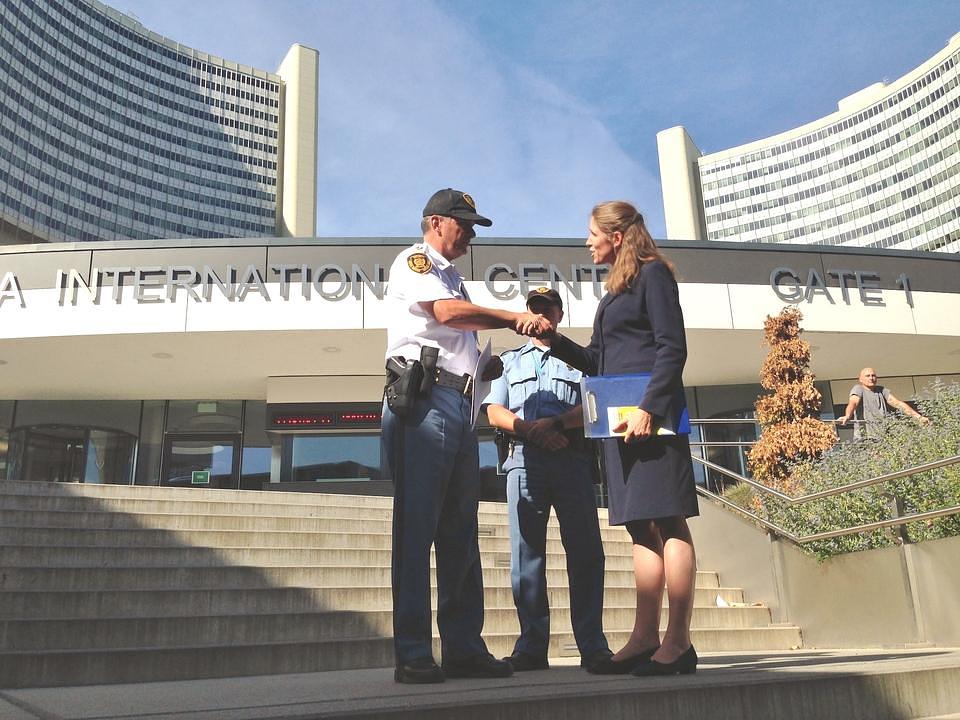 Praktikantica Katja daje informativni materijal sigurnosnom inspektoru UNOV-a
