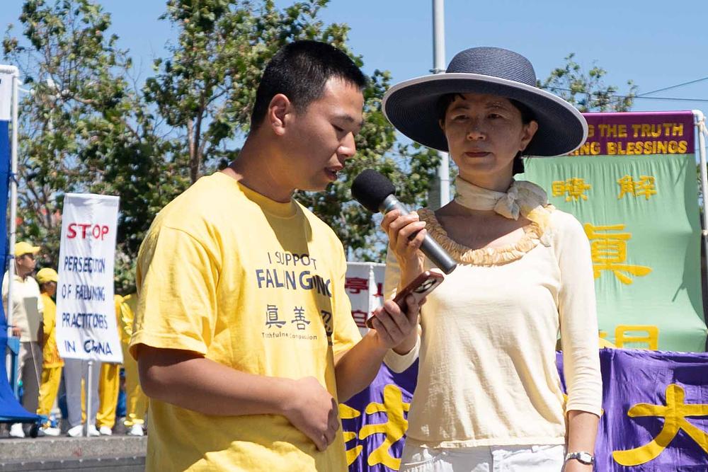 Falun Gong praktikant Wang Longbiao (lijevo) govorio je na skupu. 
