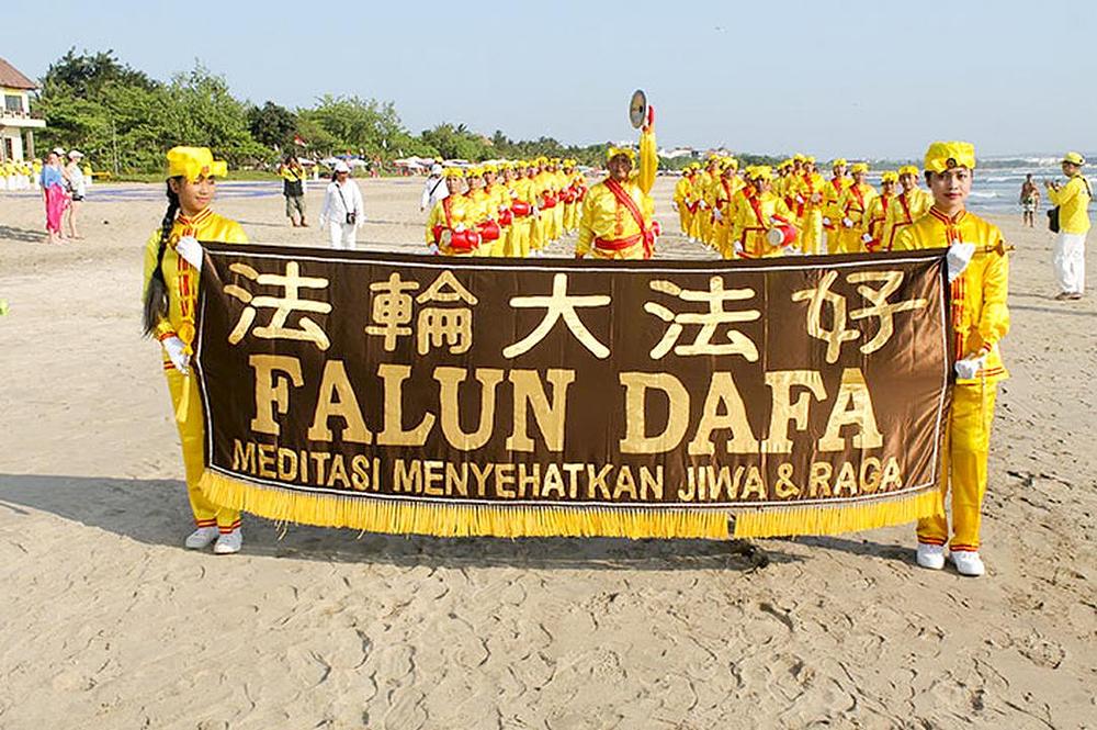 Povorka nekoliko stotina Falun Dafa praktikanata na plaži.