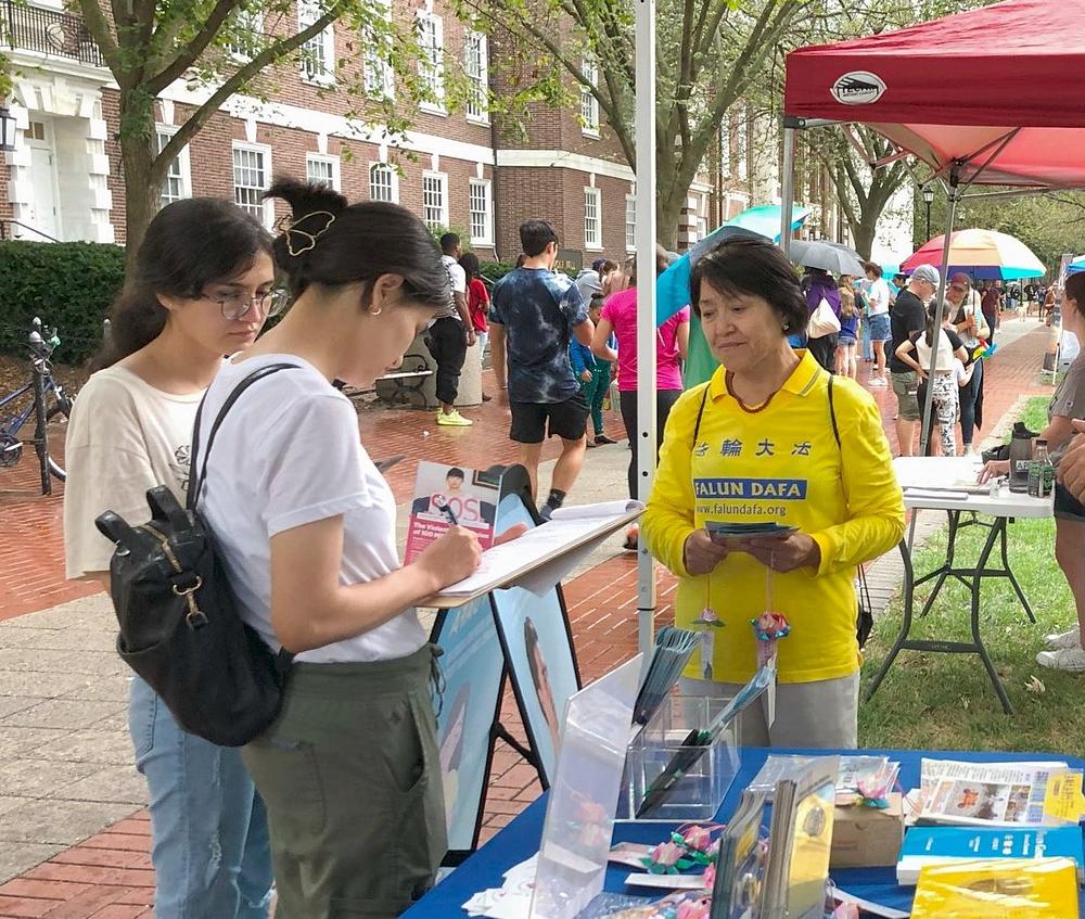 Posjetitelji potpisuju peticiju podrške Zakonu o zaštiti Falun Gonga.
