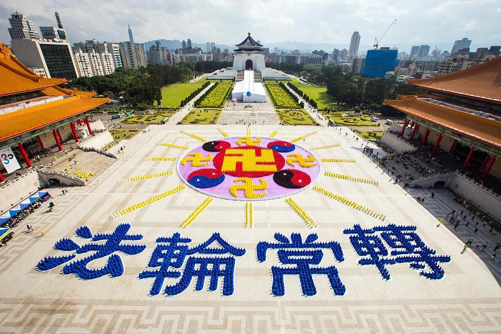 Uzorak Zakonskog Kotača (Falun znak) i četiri kineska znaka koji znače “Zakonski Kotač se okreće bez prestanka”, formiranih od strane 6.300 Falun Gong praktikanata na Trgu slobode, Taipei, 28. studenog 2015. godine