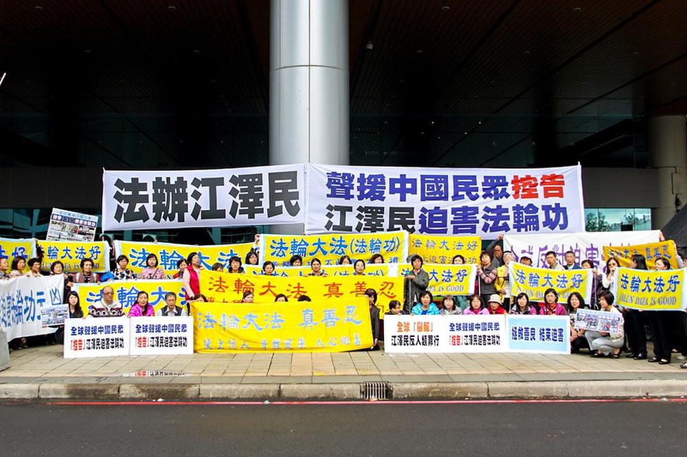 Praktikanti Falun Gonga drže velike transparente ispred Tanyuan aerodroma 30. novembra, u vrijeme kada je Chen Deming stigao na aerodrom. Na transparentima piše: „Privedite Jiang Zemina pred lice pravde“,  „Zaustavite progon Falun Gonga“, „Podrška kineskom narodu koji podnosi krivične prijave protiv Jiang Zemina“ itd.