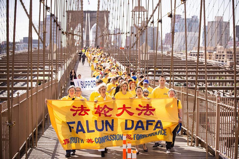Praktikanti Falun Dafa iz Njujorka 15. maja 2015. godine marširaju preko brooklingskog mosta u Njujorku.