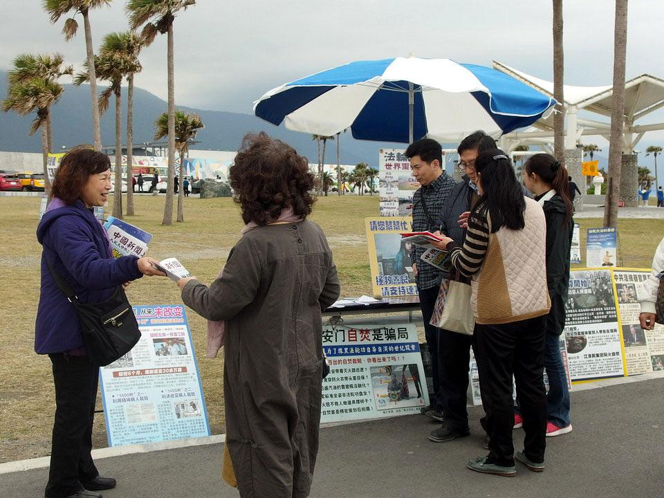 Turisti iz Kine zastaju kako bi naučili više o Falun Gongu. 