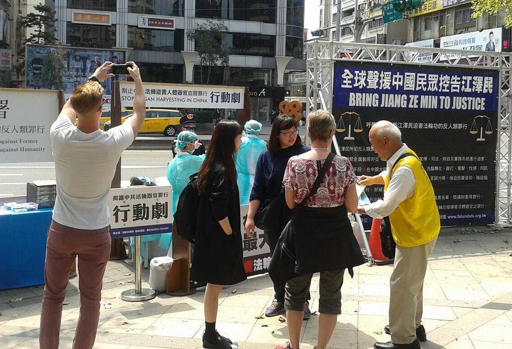 Praktikanti Falun Gonga iz Taipeia rade na podizanju javne svijesti o progonu Falun Gonga u Kini. Jedan praktikant pojašnjava jezivi prizor prolaznicima.