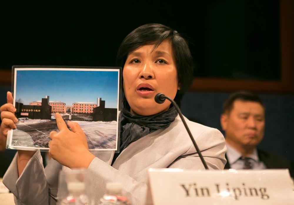 Praktikantica Yin Liping pokazuje zastupnicima u kongresu fotografiju logora za prisilni rad Masanjia