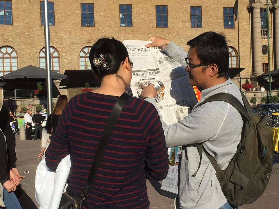 Kineski turisti čitaju Falun Gong bilten.
