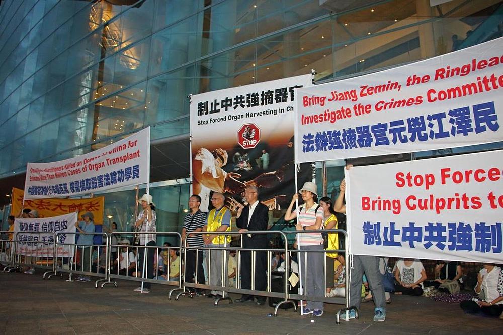 Praktikanti Falun Gonga drže transparente na skupu ispred Centru za konvencije i izložbe u Hong Kongu, gdje je Društvo za transplantaciju održavalo 26. međunarodni kongres. Oni su zahtijevali okončanje zločina žetve organa u Kini, u kojoj su stotine hiljada zatvorenika savjesti kako se vjeruje ubijeno zbog njihovih organa. 